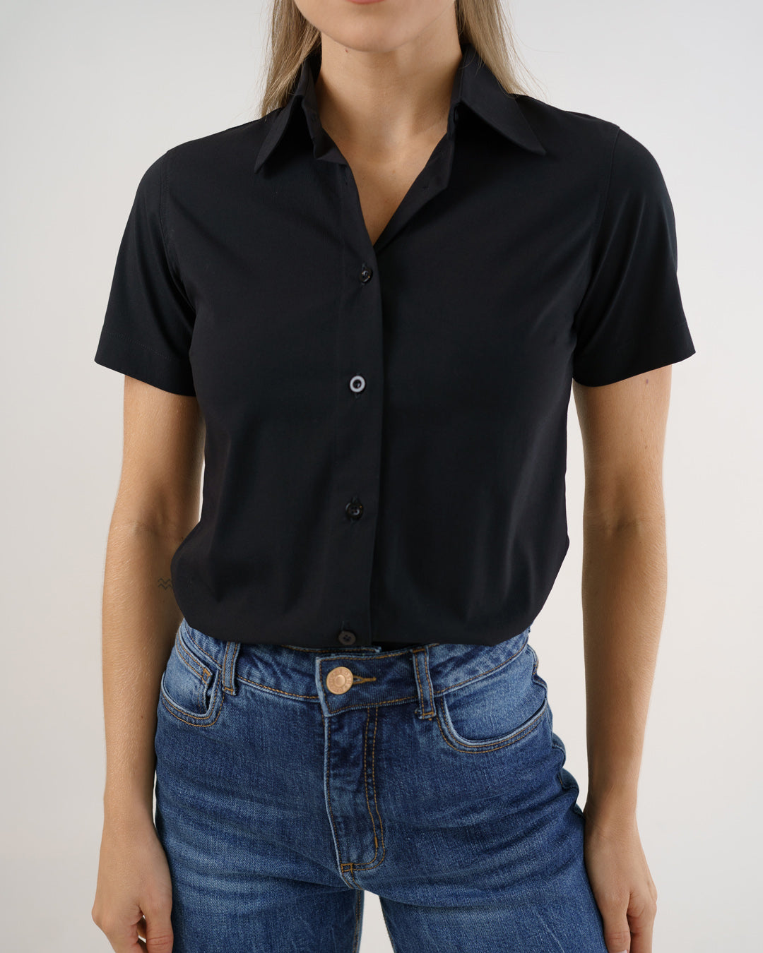 Camisa social feminina manga curta preta em detalhe aproximado do torso, com botoes frontais e gola — foto 5