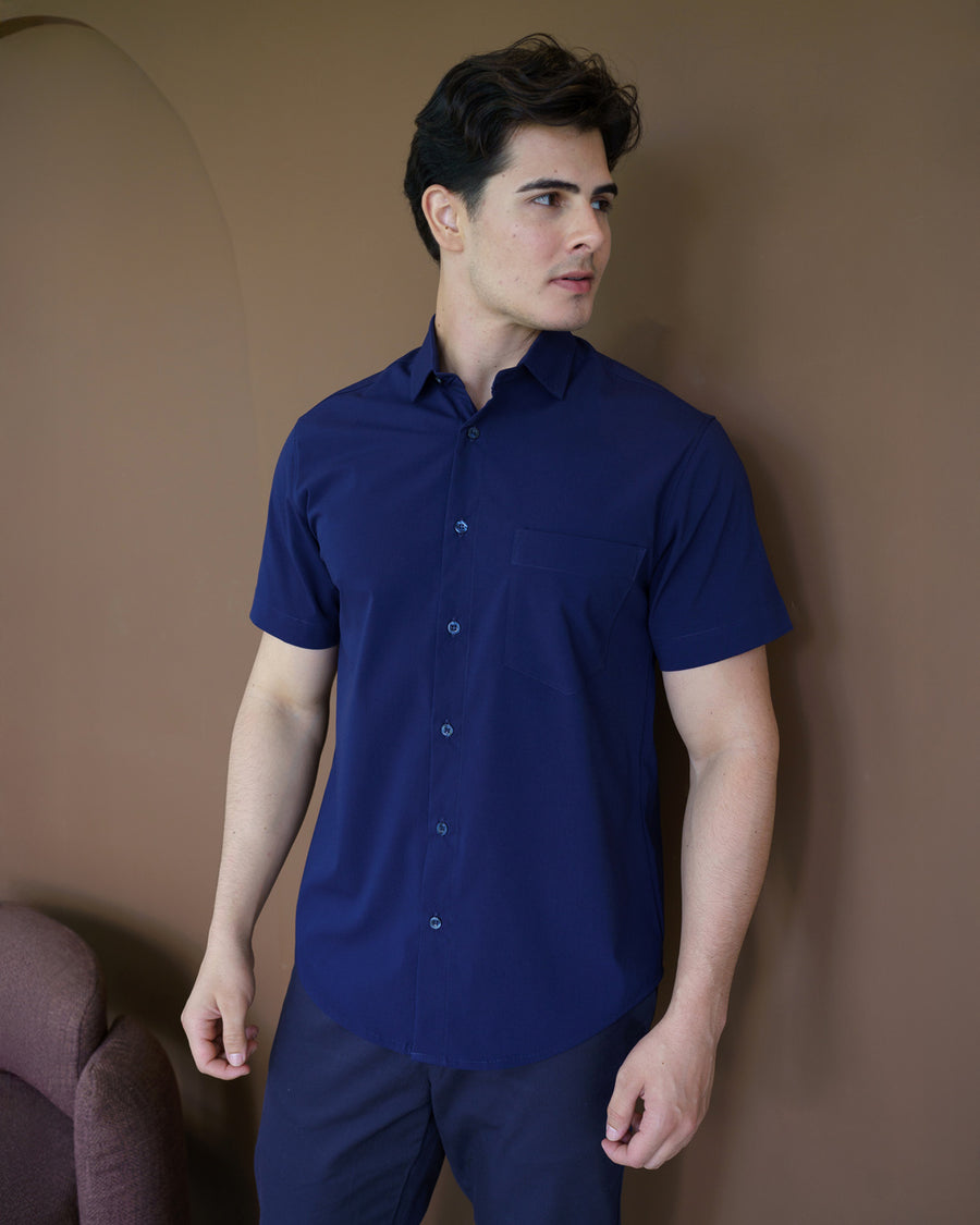 Camisa social masculina manga curta azul marinho em meio corpo frontal, com gola classica e bolso no peito
