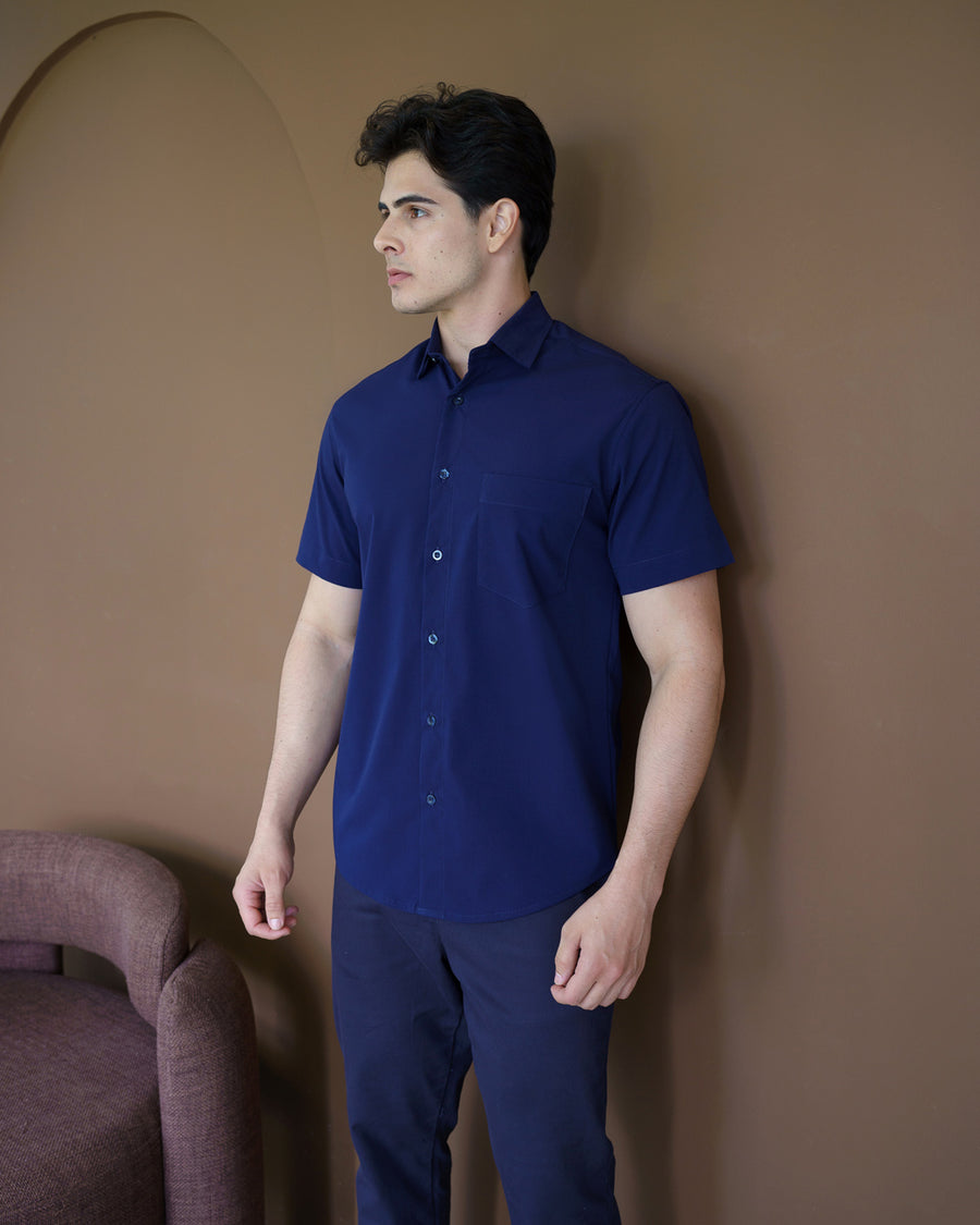 Camisa social masculina manga curta azul marinho em vista lateral de meio corpo, mostrando caimento slim e bolso