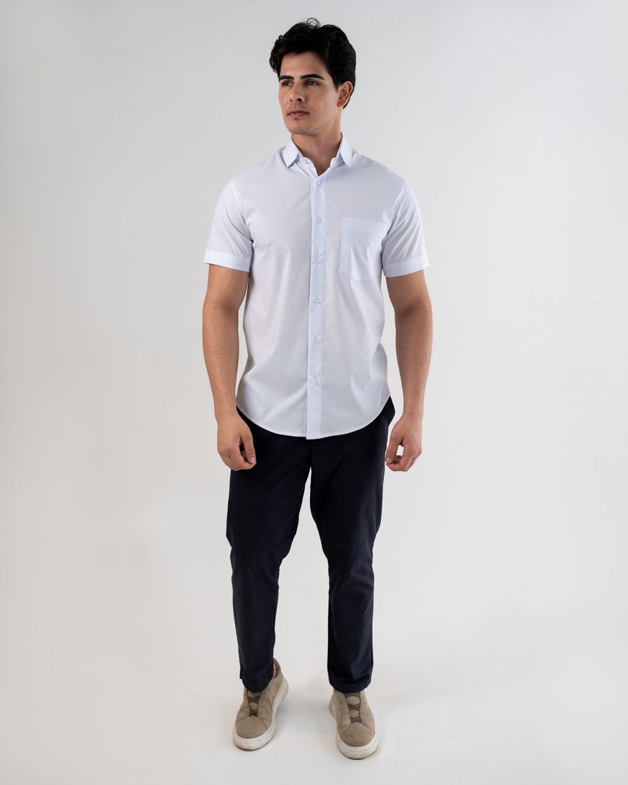 Camisa social masculina manga curta branca em foto de corpo inteiro, modelo com calca azul escura