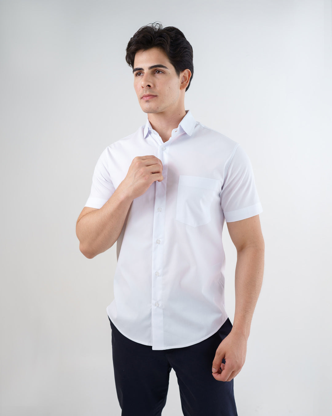 Camisa social masculina manga curta branca vestida por modelo, vista frontal com bolso no peito e botoes