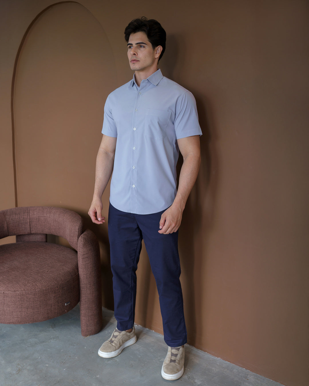 Camisa social masculina manga curta cinza claro em corpo inteiro de lado, modelo com calca azul escura — foto 4