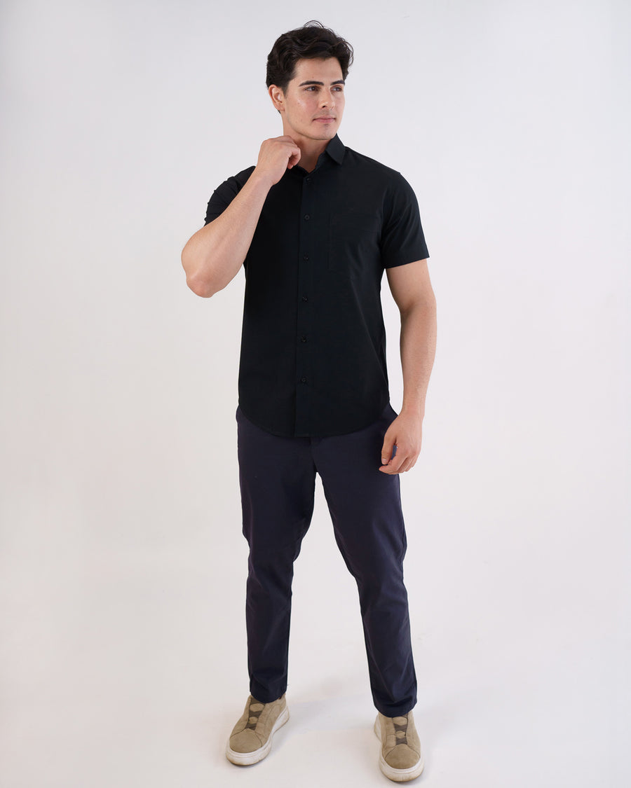 Camisa social masculina manga curta preta em corpo inteiro frontal, modelo ajustando a gola da camisa