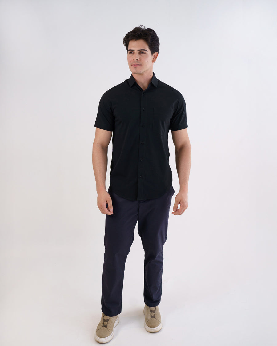 Camisa social masculina manga curta preta em foto de corpo inteiro, modelo com calca azul escura