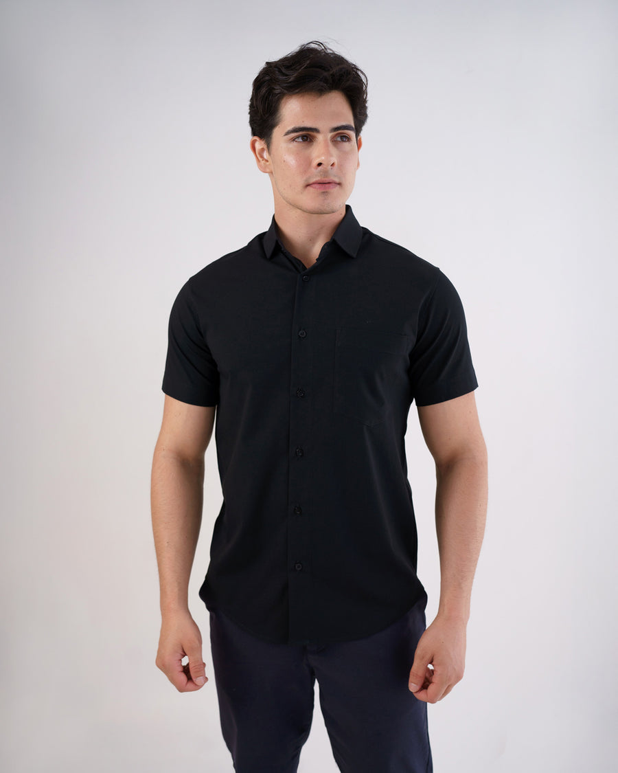 Camisa social masculina manga curta preta vestida por modelo, vista frontal com bolso no peito e botoes