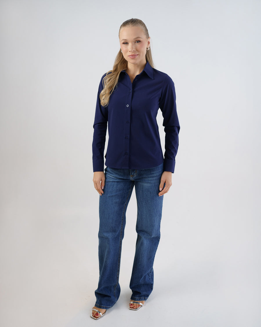 Camisa social feminina manga longa azul marinho em foto de corpo inteiro, modelo com calca jeans azul