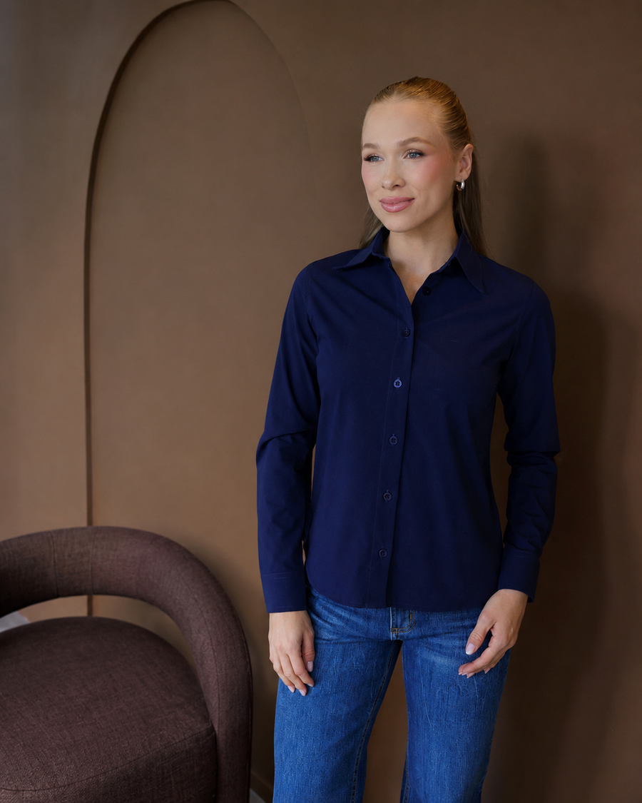 Camisa social feminina manga longa azul marinho vestida por modelo em pe, vista frontal com botoes fechados