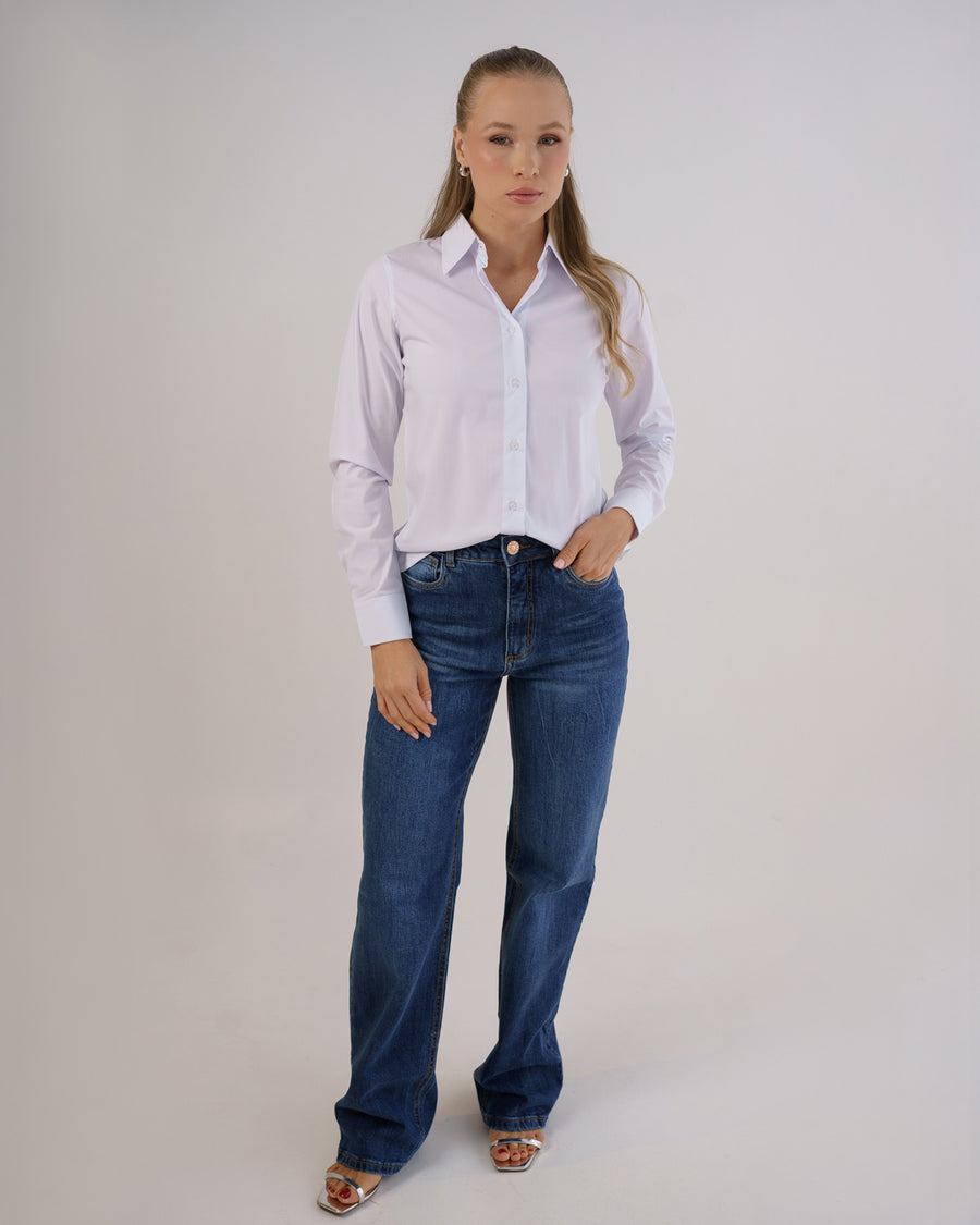Camisa social feminina manga longa branca em foto de corpo inteiro, modelo combinando com calca jeans azul