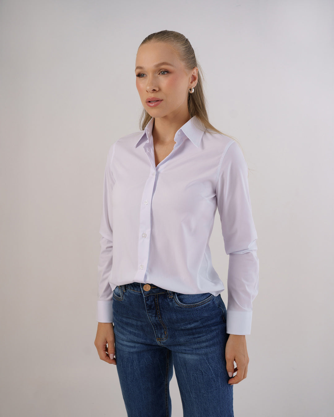 Camisa social feminina manga longa branca em meio corpo levemente de lado, mostrando caimento slim e punho — foto 5