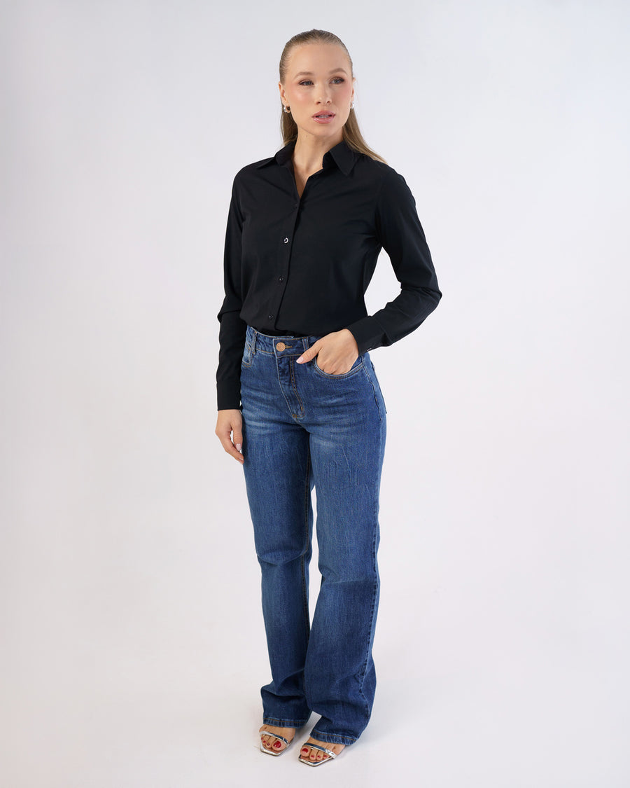 Camisa social feminina manga longa preta em foto de corpo inteiro, modelo com mao no bolso da calca jeans