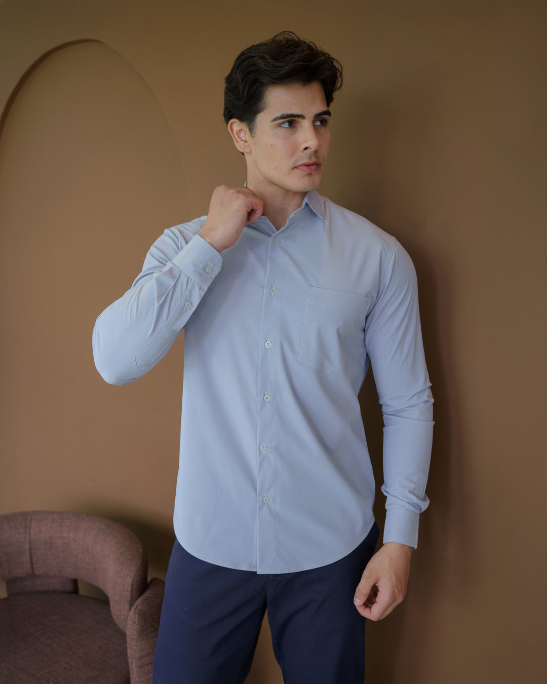 Camisa social masculina cinza claro manga longa, modelo com a mão junto à gola mostrando caimento slim — foto 5