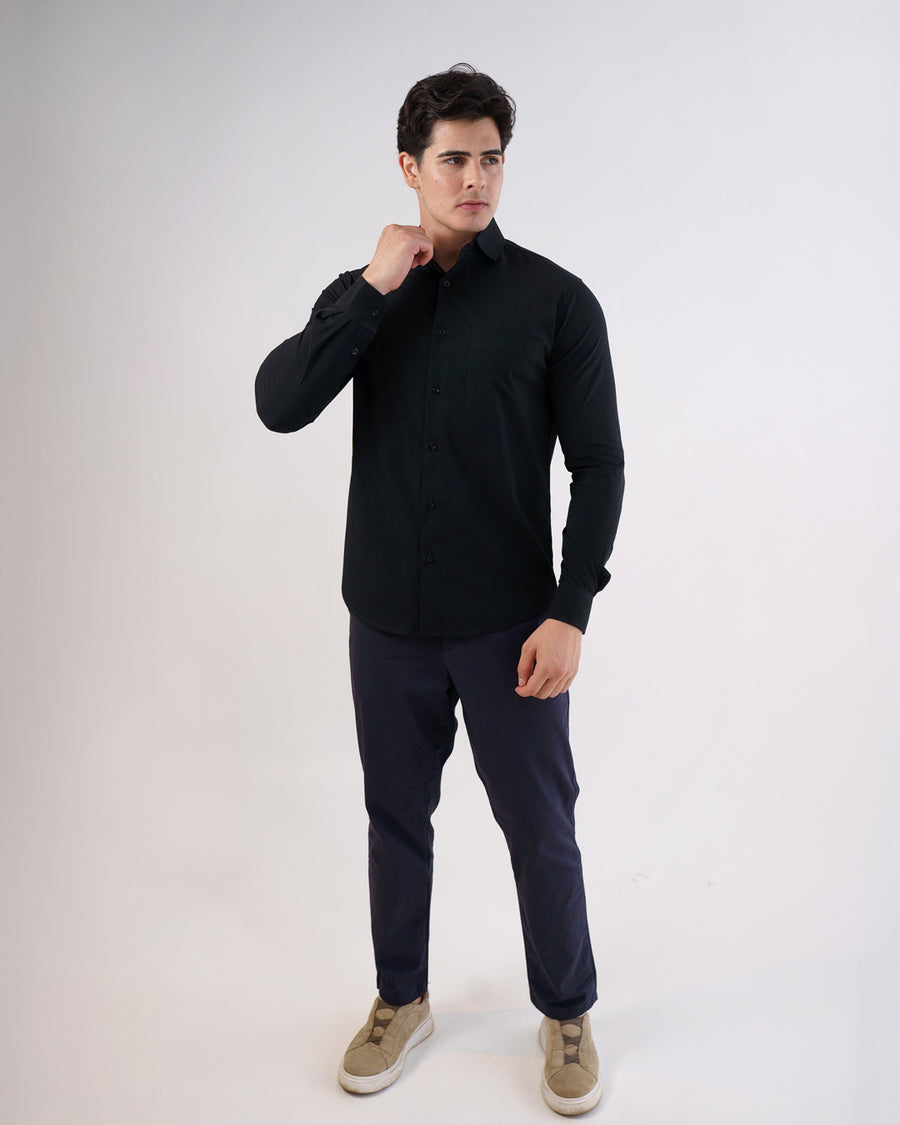 Camisa social masculina preta slim em corpo inteiro, modelo com a mão junto à gola mostrando caimento
