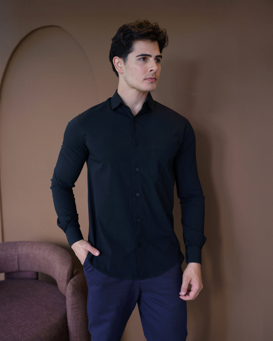 Camisa social masculina preta slim, meio corpo frontal com abotoamento completo e mão no bolso da calça