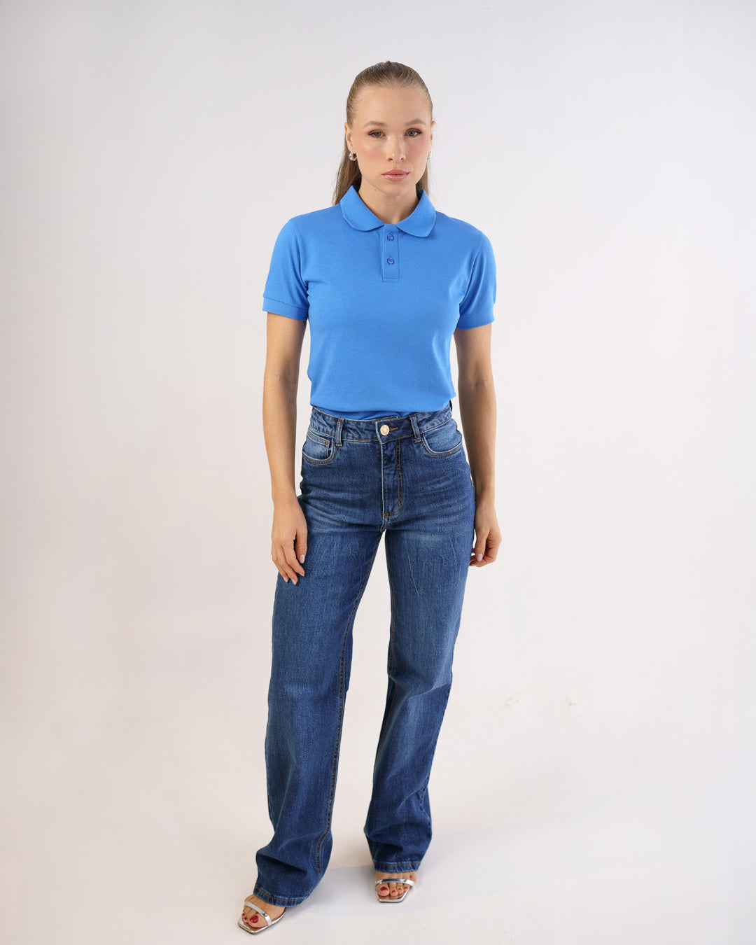 Camiseta polo feminina premium azul celeste em corpo inteiro, modelo veste a polo com calça jeans — foto 3