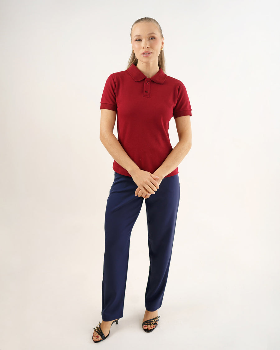 Camiseta polo feminina bordô em corpo inteiro, modelo veste a polo com calça azul marinho