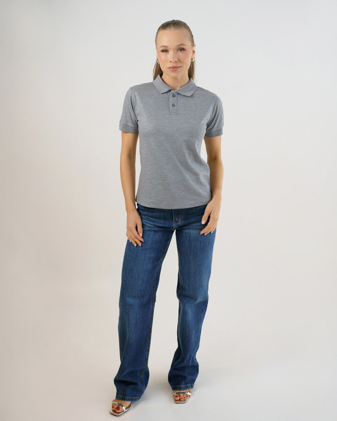 Camiseta polo feminina premium cinza claro em corpo inteiro frontal, usada com calça jeans azul — foto 3