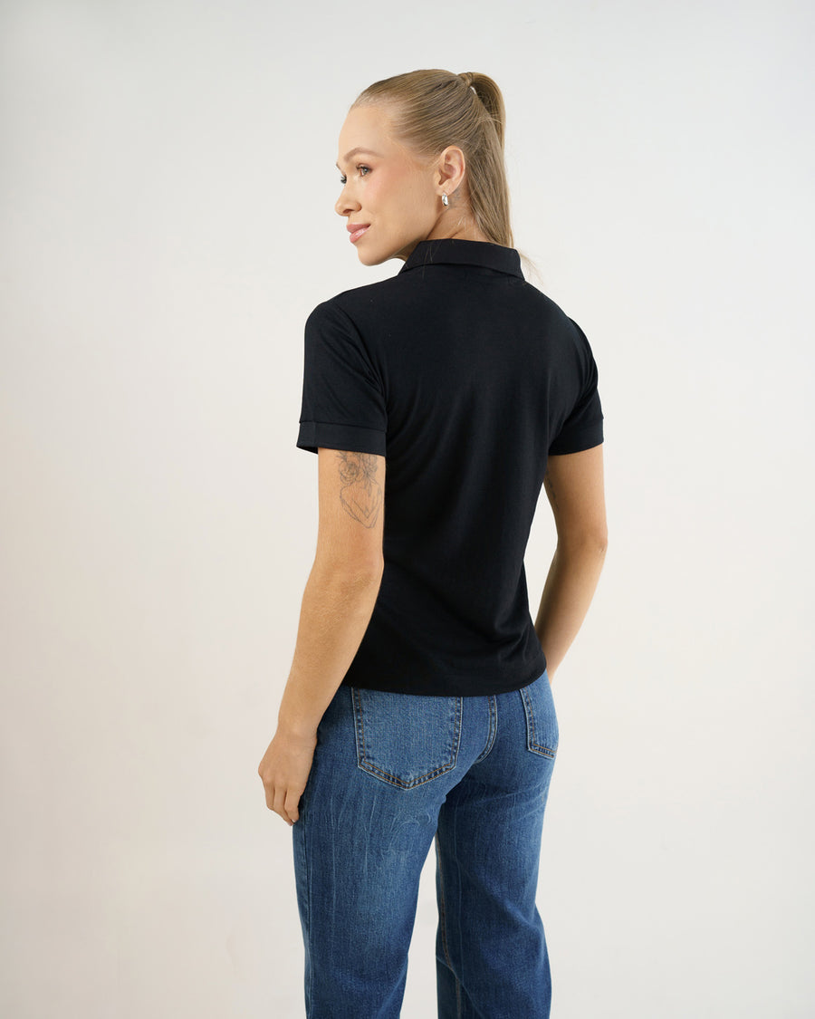 Camiseta polo feminina preta, vista de costas mostrando caimento ajustado e mangas com punho dobrado
