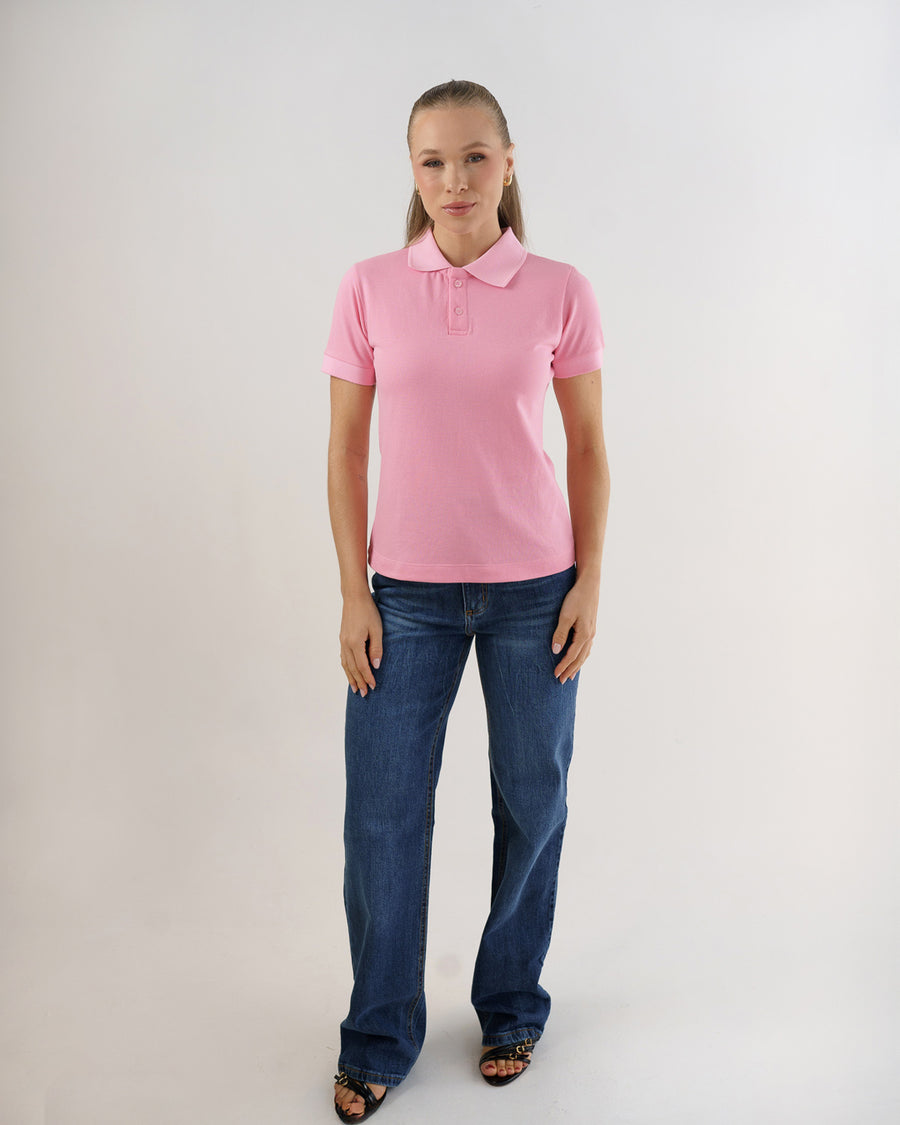Camiseta polo feminina premium rosa claro em corpo inteiro, modelo veste a polo com calça jeans azul