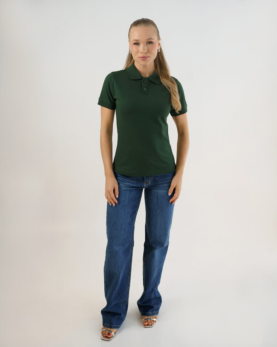 Camiseta polo feminina verde musgo em corpo inteiro, modelo veste a polo com calça jeans azul