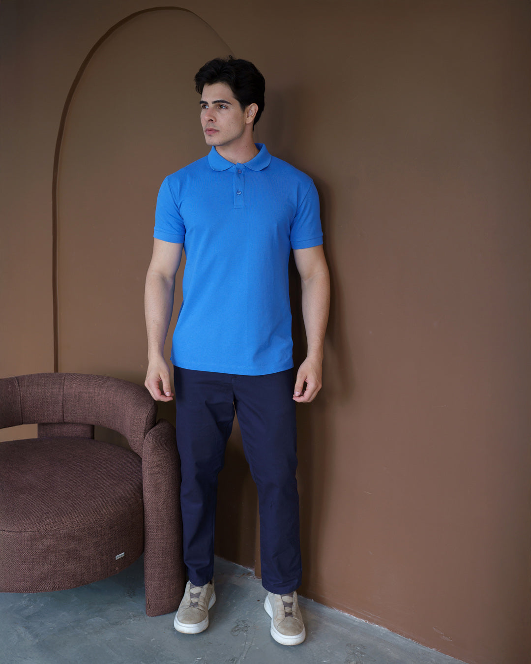 Camiseta polo masculina azul celeste em corpo inteiro, modelo veste a polo com calça azul marinho — foto 4
