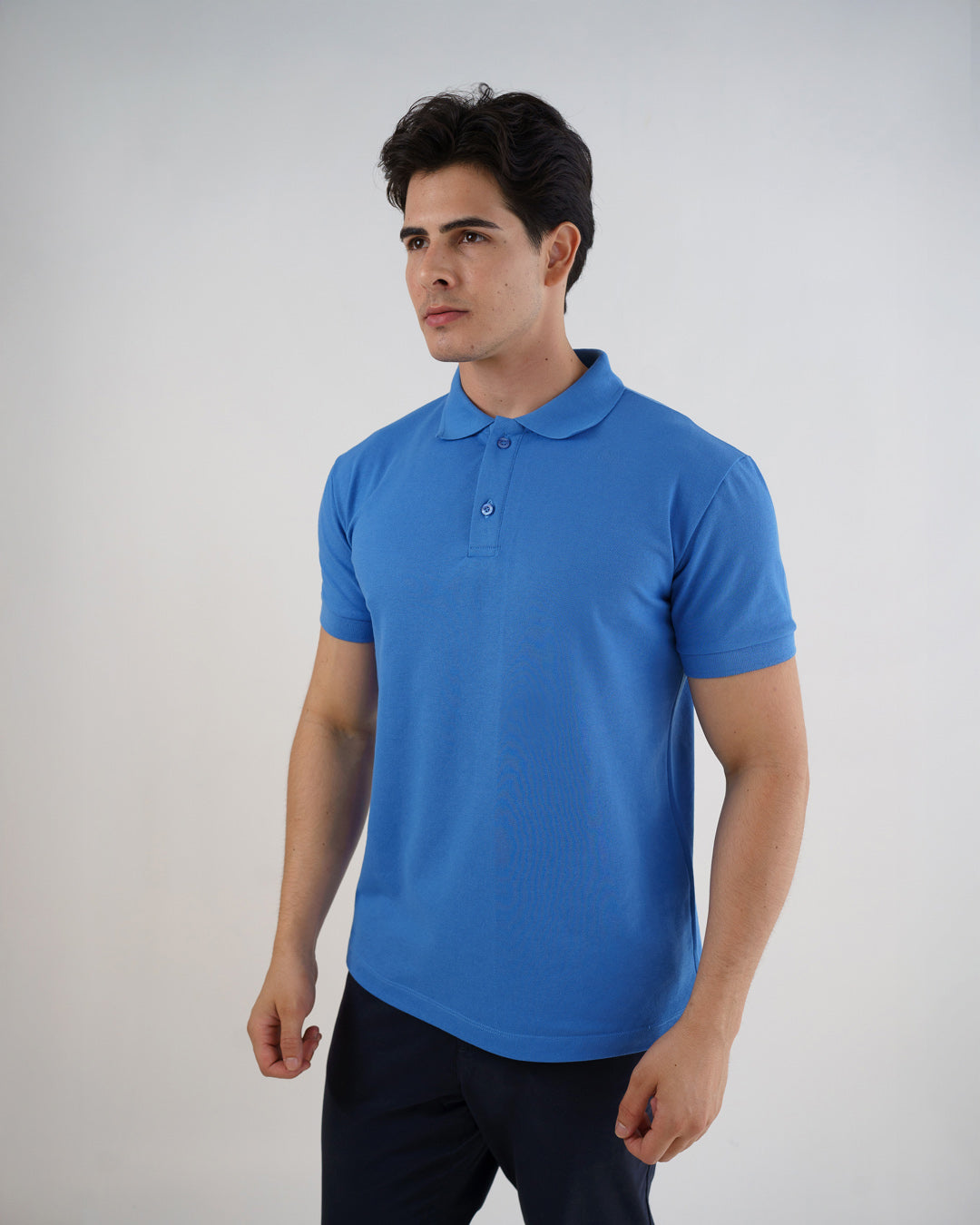 Camiseta polo masculina premium azul celeste em meio corpo de leve perfil, com gola e dois botões