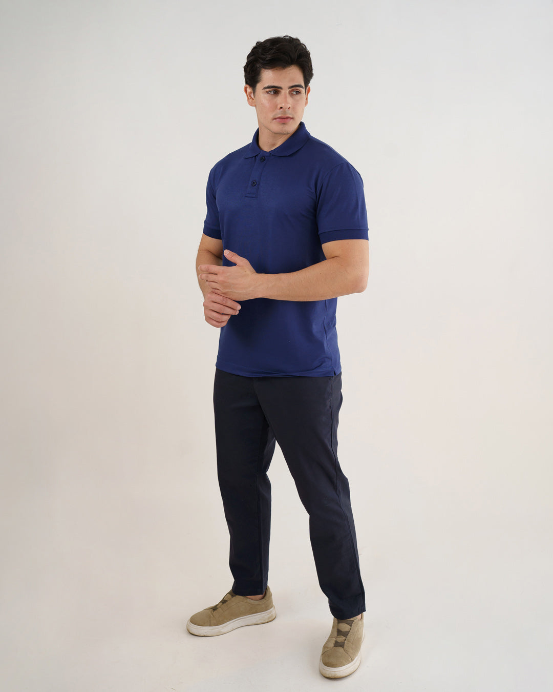 Camiseta polo masculina premium azul marinho em corpo inteiro, modelo com braços cruzados à frente — foto 4