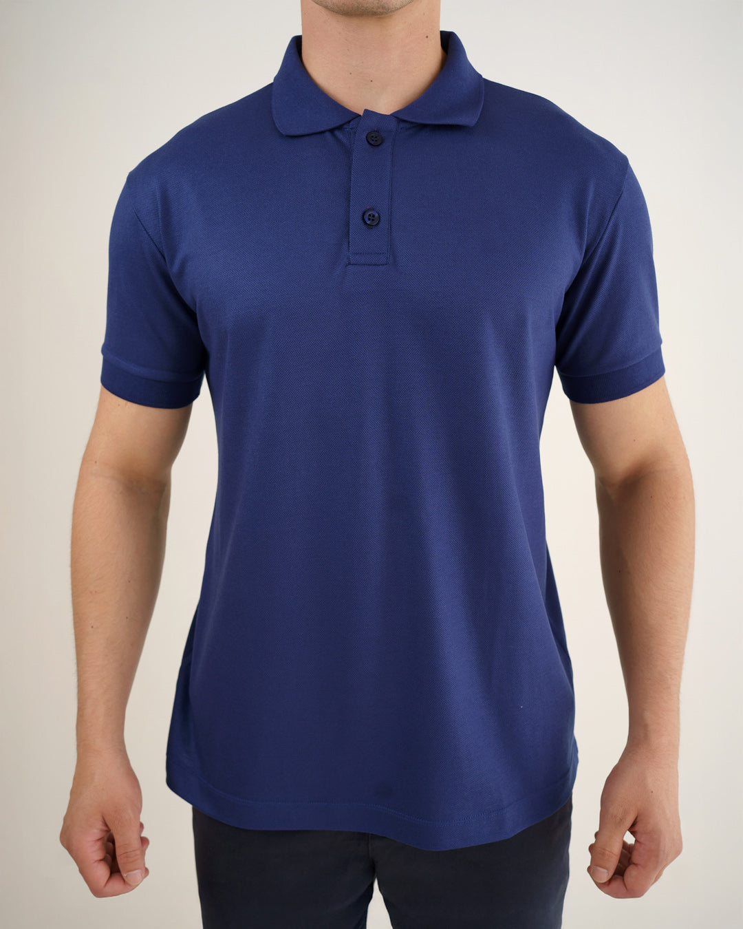 Camiseta polo masculina azul marinho, detalhe frontal aproximado da gola, botões e tecido piquê — foto 3