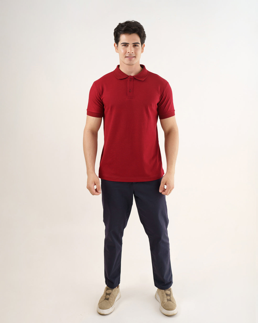 Camiseta polo masculina premium bordô de frente em corpo inteiro, caimento reto sobre calça azul-marinho — foto 4