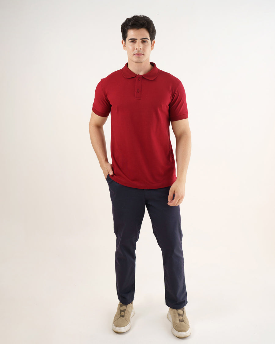 Camiseta polo masculina premium bordô em foto de corpo inteiro, modelo com mão no bolso e calça azul-marinho