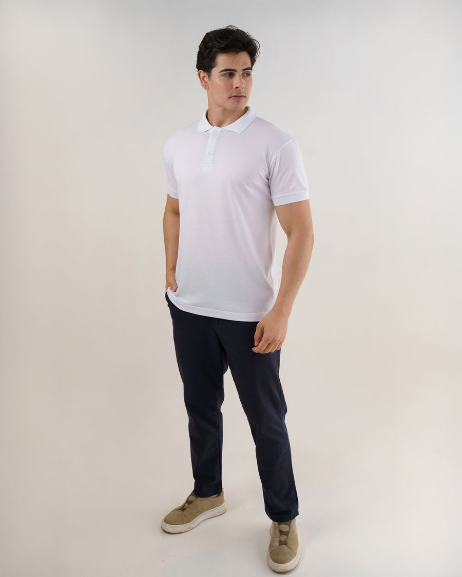 Camiseta polo masculina premium branca em ângulo lateral de corpo inteiro, mostrando caimento e manga curta