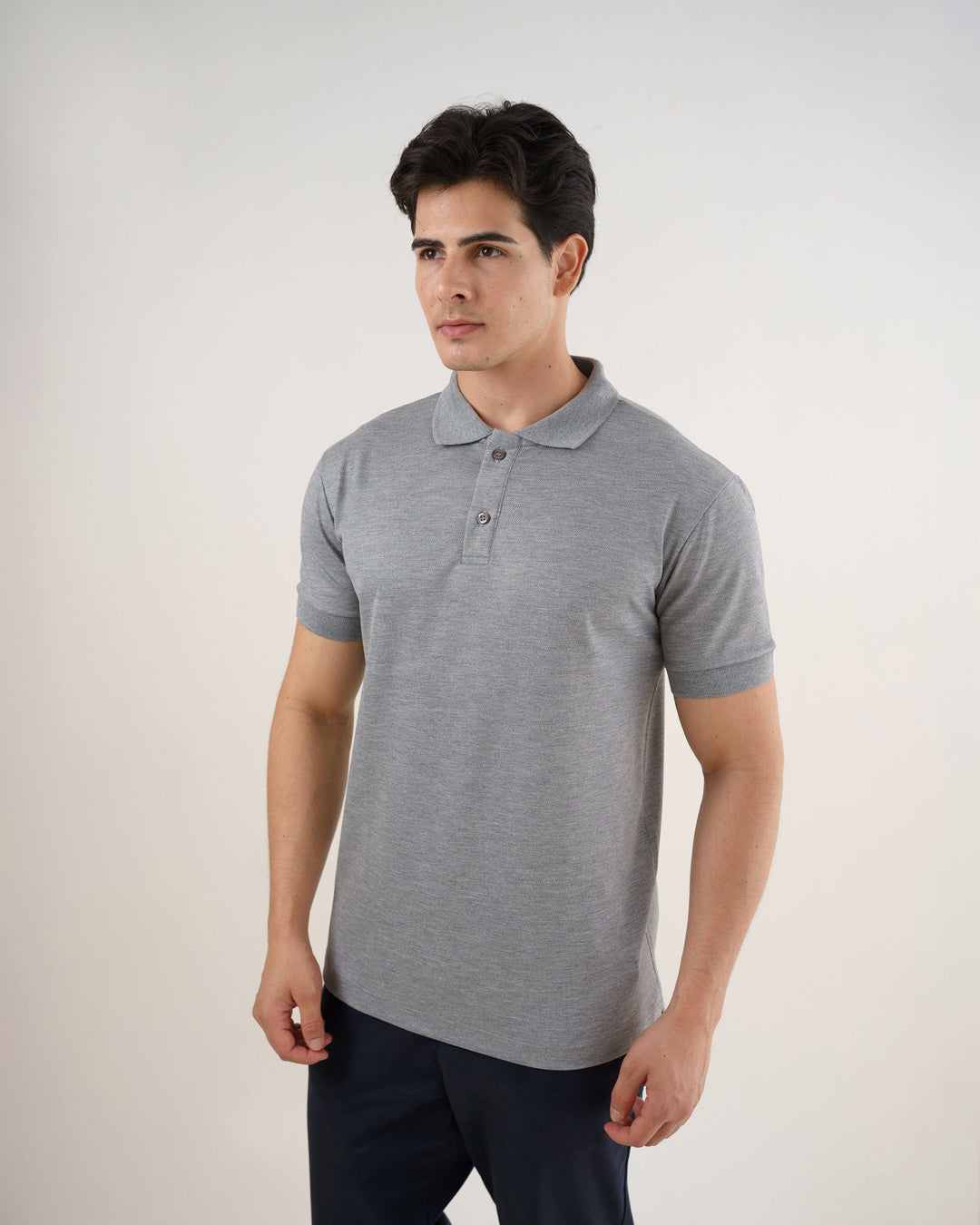 Camiseta polo masculina premium cinza claro em ângulo lateral de meio corpo, mostrando gola, botões e manga com punho — foto 3