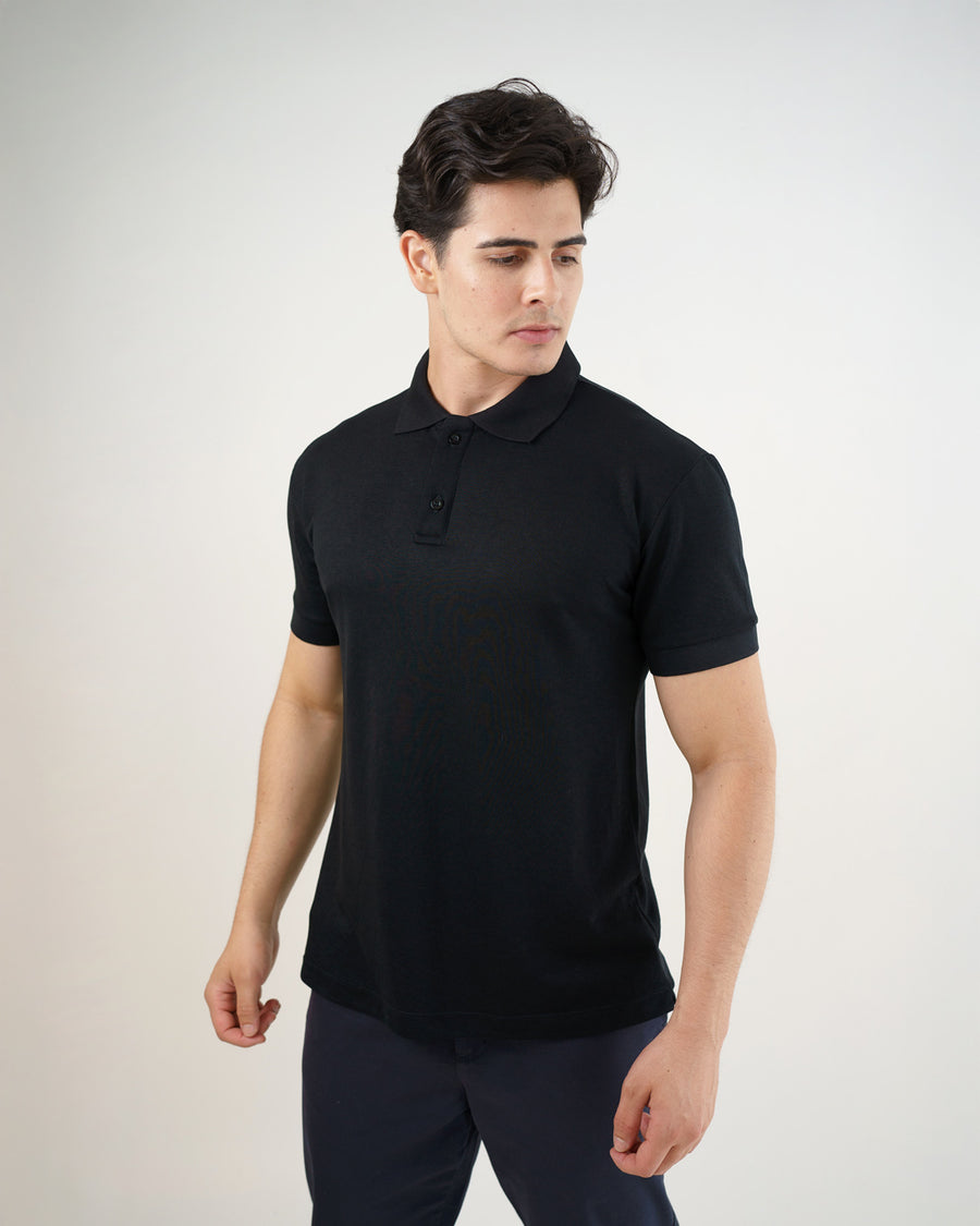 Camiseta polo masculina premium preta em ângulo lateral de meio corpo, mostrando gola, botões e caimento da peça
