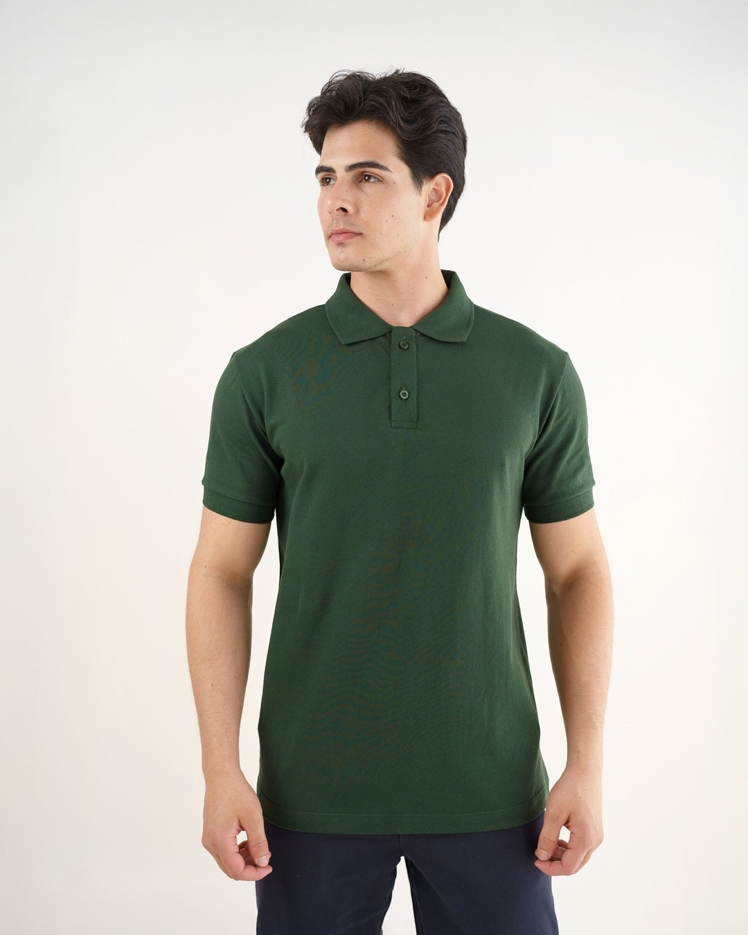 Camiseta polo masculina premium verde musgo vestida por modelo, vista frontal de meio corpo com gola e botões