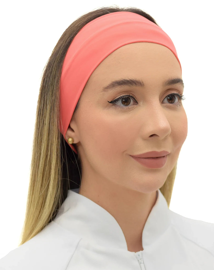 Faixa feminina coral em leve ângulo frontal, modelo de cabelo solto mostrando o ajuste da faixa na testa