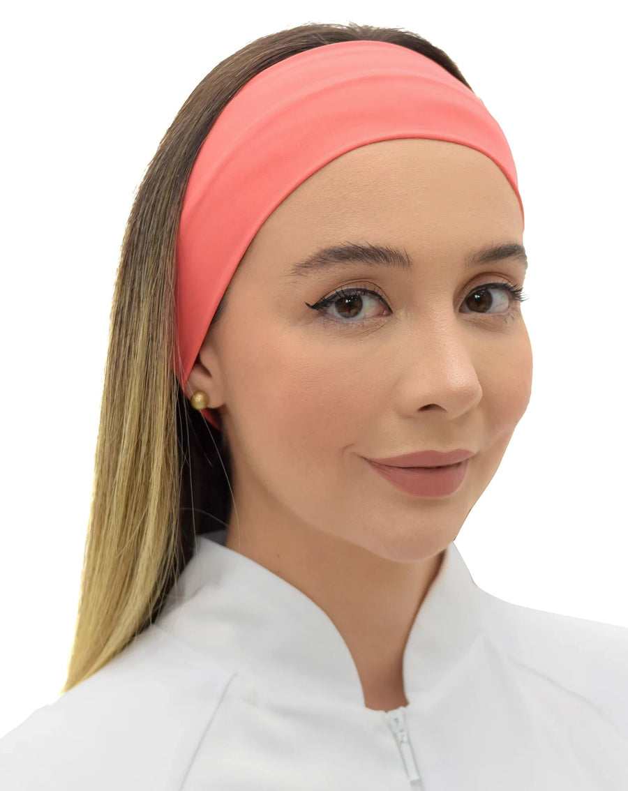 Faixa feminina coral usada na cabeça de modelo sorrindo, vista frontal mostrando a faixa larga na testa