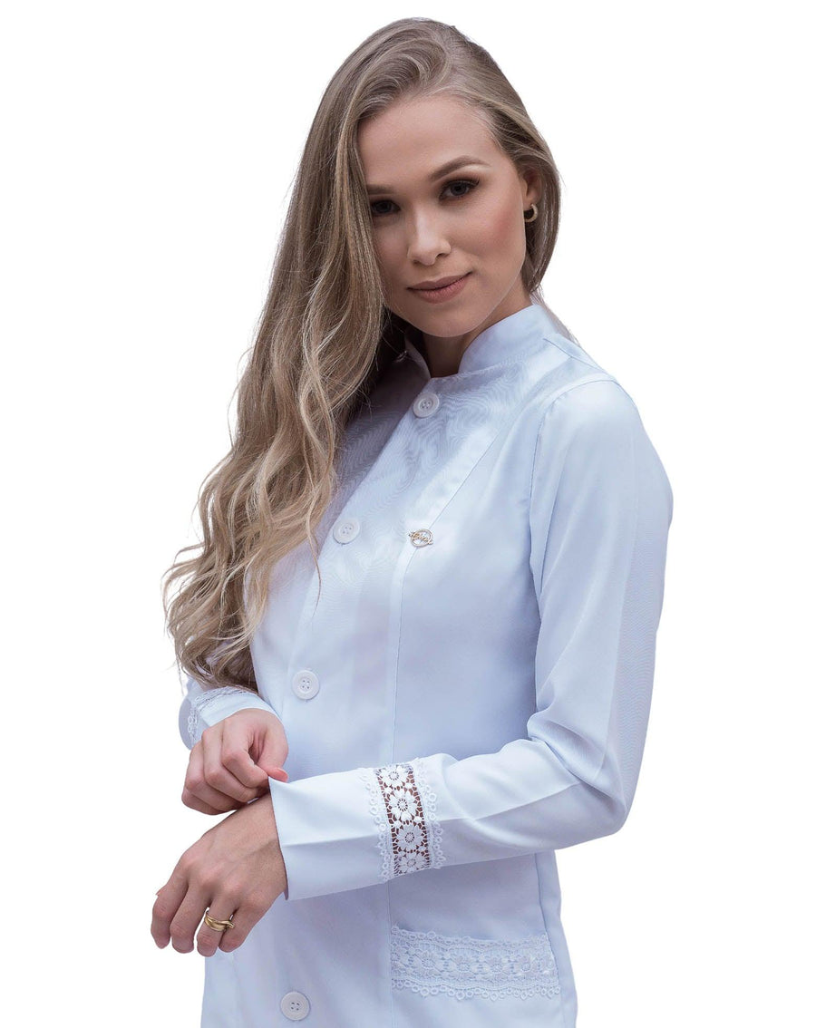 Jaleco feminino Beauty branco em meio corpo lateral, destaque para o punho com faixa de renda gripir e pin