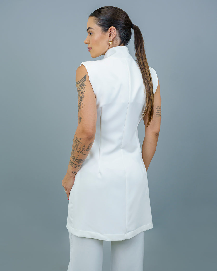 Jaleco feminino Clarice sem manga off white visto de costas na modelo, com gola alta e corte acinturado