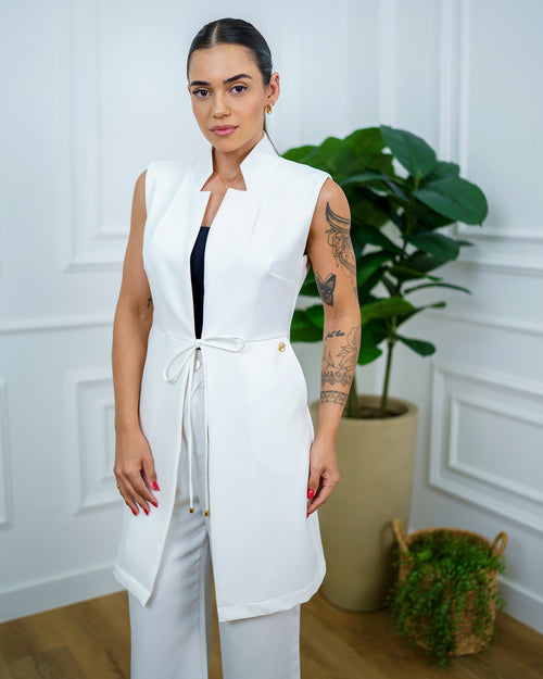 Jaleco feminino Clarice sem manga off white visto de frente, com gola estruturada e laço de amarração