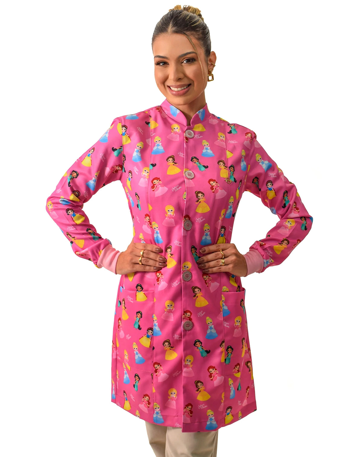 Jaleco feminino estampado Princesas pink de frente, mãos na cintura, gola padre e estampa de princesinhas