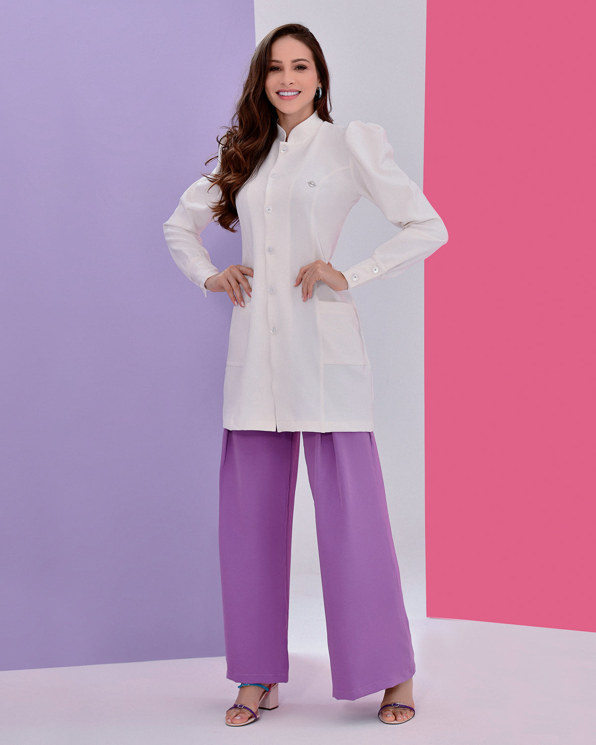 Jaleco feminino Júlia off-white em detalhe aproximado dos botões, gola padre, pin da marca e punho abotoado fundo colorido — foto 5