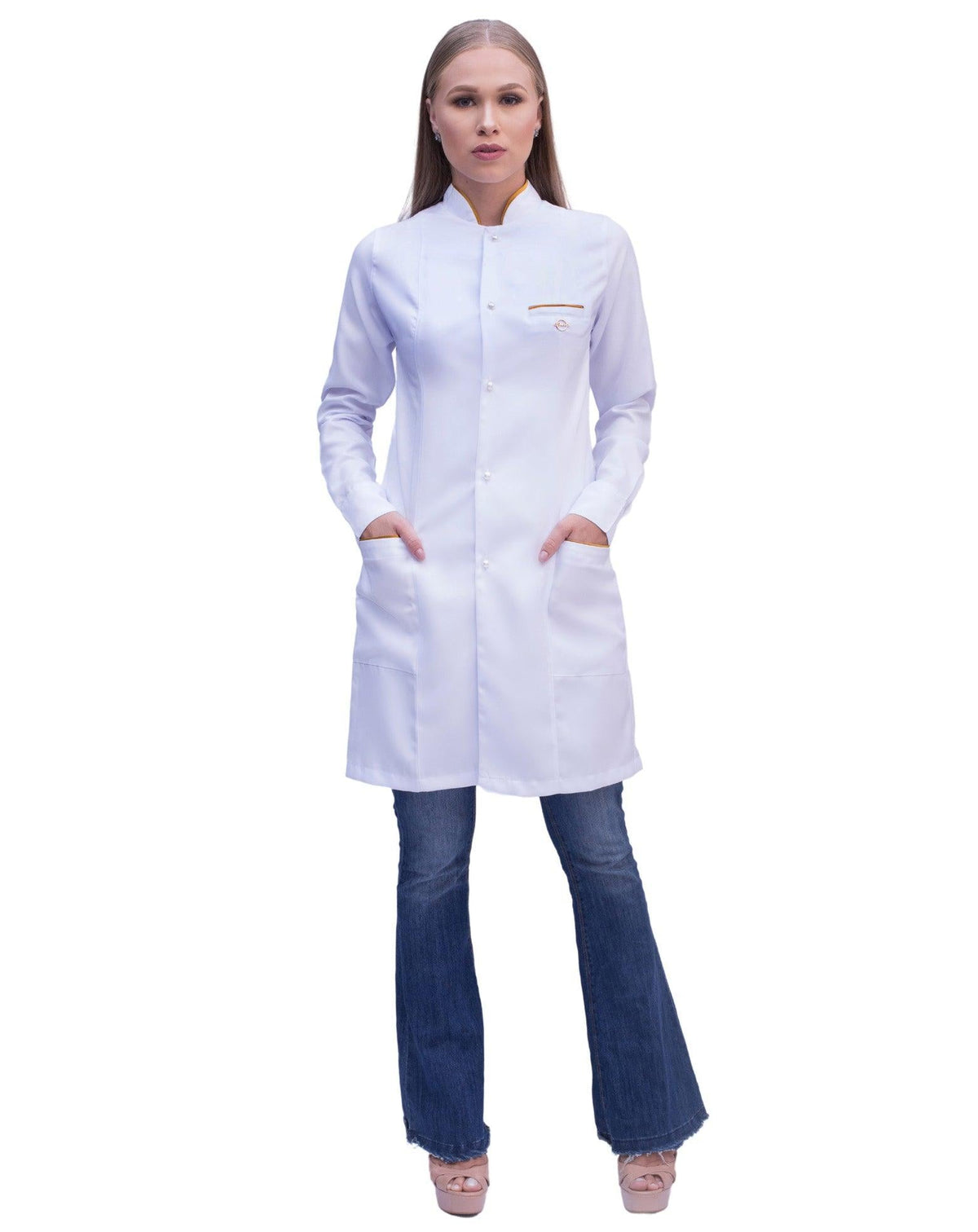 Jaleco feminino Slim Charm branco de corpo inteiro, mãos nos bolsos com viés dourado e gola padre — foto 2