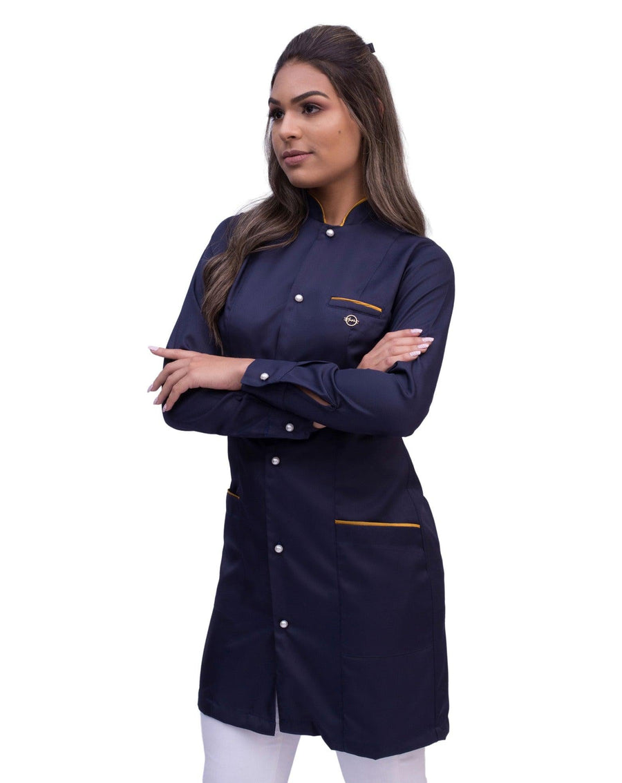 Jaleco feminino Slim Charm Color azul marinho de lado, destacando bolso com viés dourado e punho abotoado