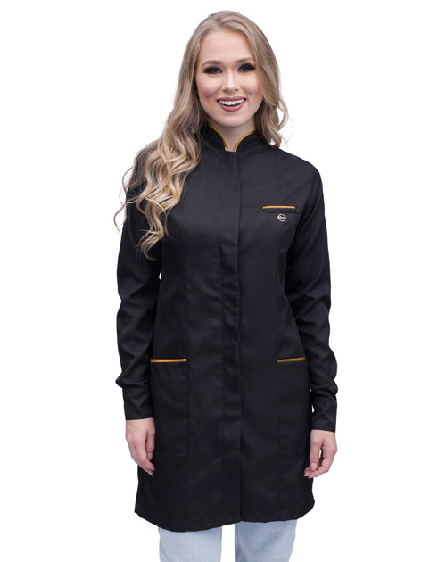 Jaleco feminino Slim Premium preto com viés dourado, vista frontal em modelo, gola padre e bolsos com friso dourado