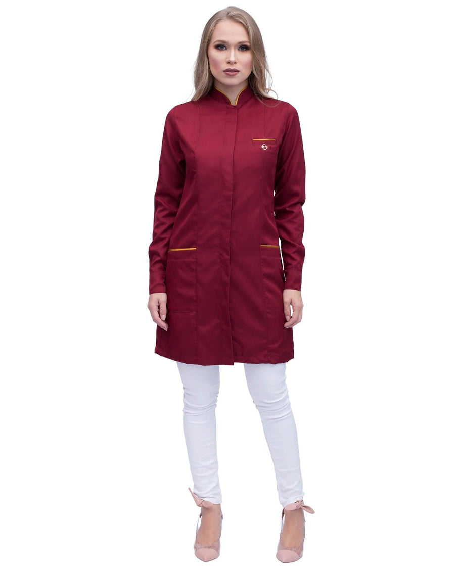 Jaleco feminino Slim Premium vinho bordô de corpo inteiro em modelo, pin dourado no peito e comprimento acima do joelho