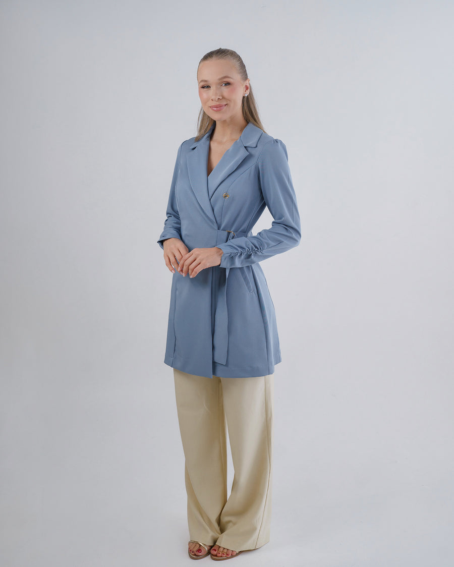 Jaleco feminino Sofia azul grafite em vista lateral, faixa transpassada na frente e punhos com franzido delicado