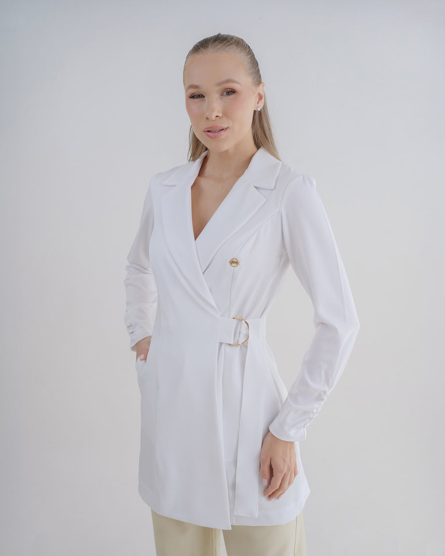 Jaleco feminino Sofia branco, vista frontal em modelo, gola de blazer transpassada e fivela dourada na cintura