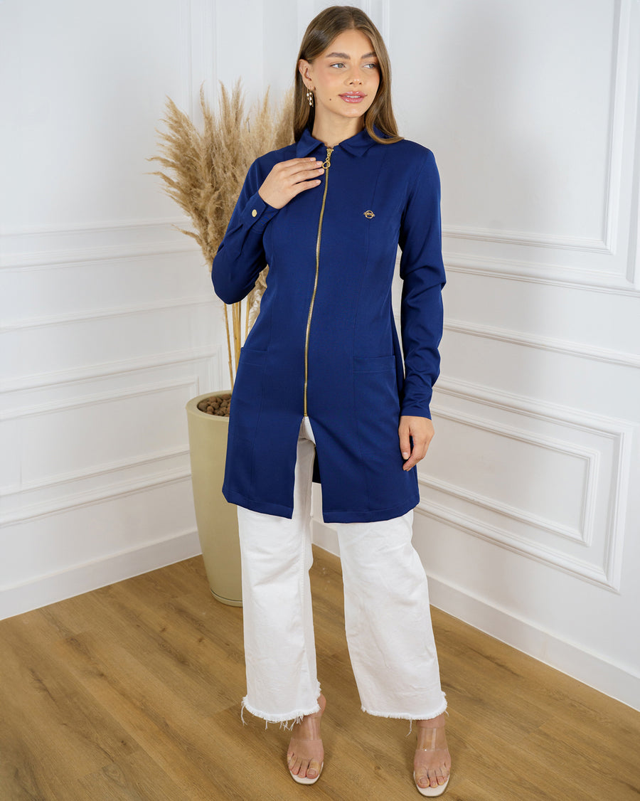 Jaleco feminino Valentine azul marinho de corpo inteiro em ambiente clássico, zíper dourado e bolsos frontais