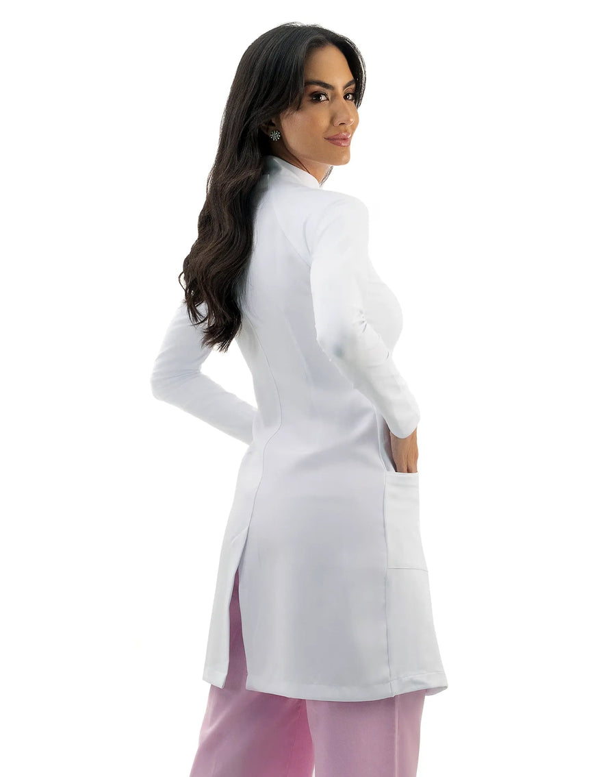 Jaleco feminino Vicky branco visto de costas, mostrando o caimento acinturado, bolso lateral e fenda na barra