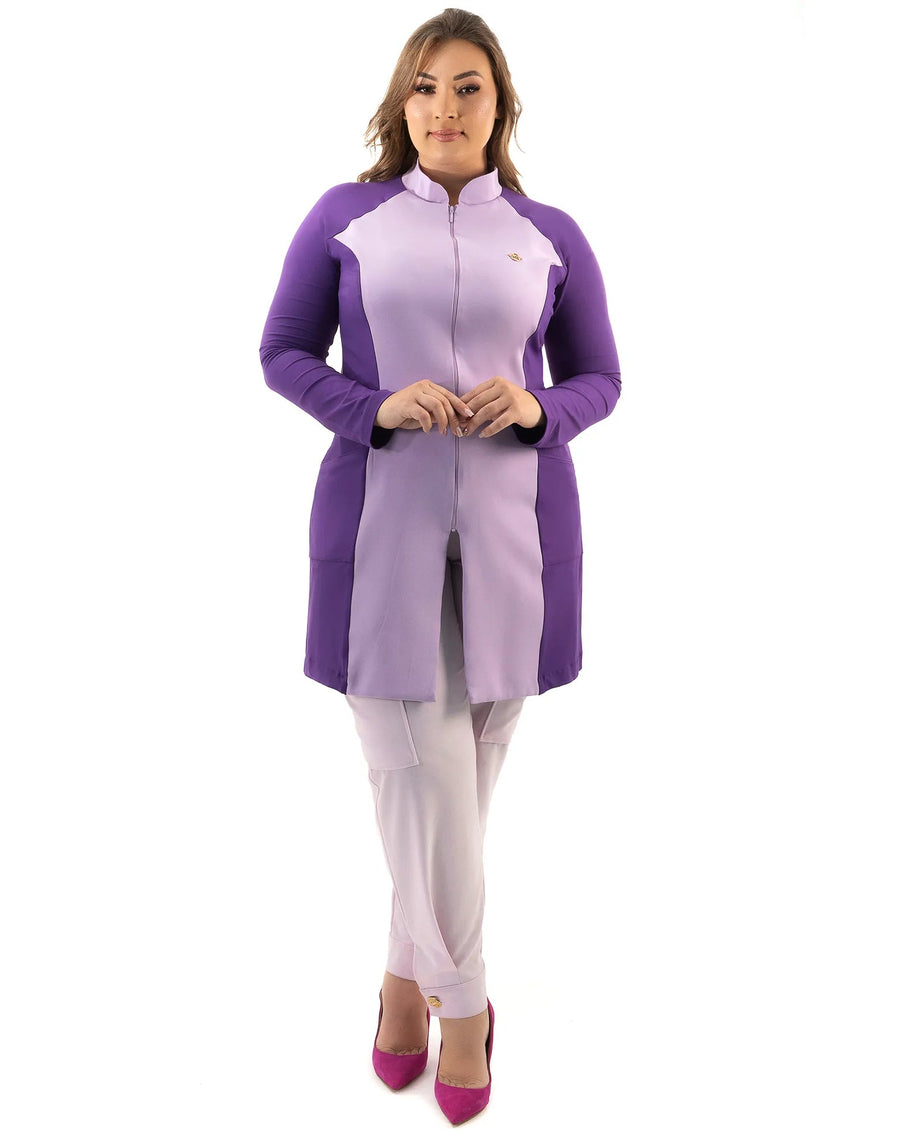 Jaleco feminino Vicky lavanda com roxo de corpo inteiro em modelo plus size, com calça lilás e zíper frontal