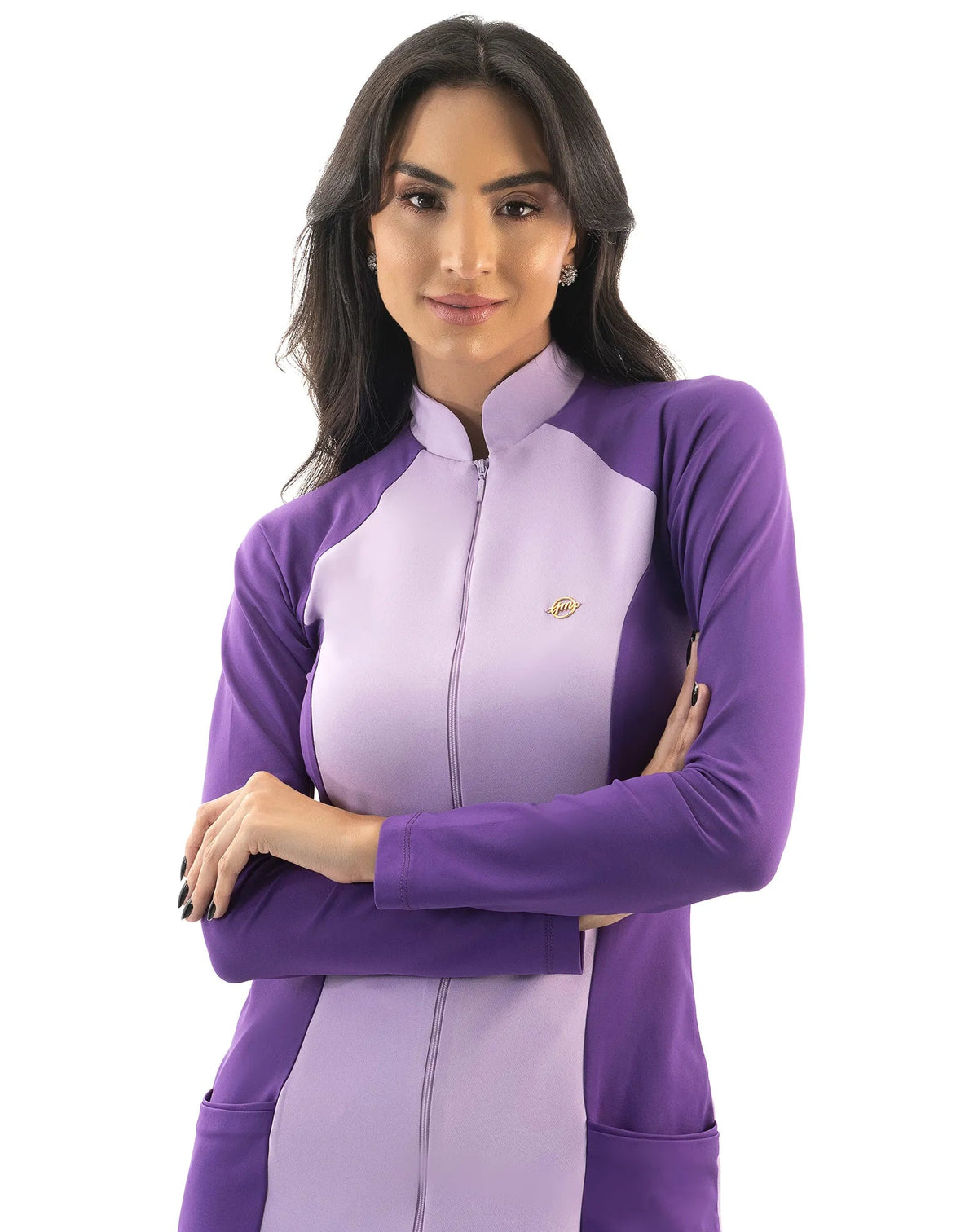 Jaleco feminino Vicky lavanda com roxo em detalhe da gola alta, zíper e pin dourado, modelo de braços cruzados — foto 3